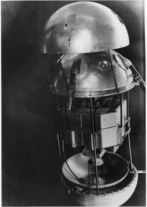 Maketa Sputniku-1 v rozloženém stavu. Je patrné, že první družice měla jen rudimentární přístrojové vybavení, zhruba uprostřed jsou zřetelné osmihranné vysílače.