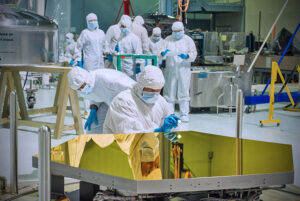 Technik z NASA práve skúma jedno z 18 zrkadiel, ktoré sa zložia dokopy a vytvoria tak 6,5m veľké primárne zrkadlo Vesmírneho Teleskopu Jamesa Webba.