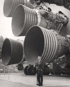 Wernher von Braun před spodní částí rakety Saturn V s pěticí motorů F-1.