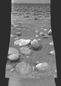 Neupravená fotografie z povrchu Titanu. Po přistání byla pořízena jen jedna jediná protože kamery na sondě nebyly pohyblivé a většina z nich mířila dolů pod sebe.