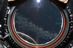 Pohled na Zemi přes kruhové okno modulu Cupola