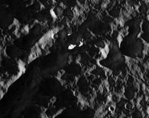 Uprostřed této fotky vidíme pole s uměle zvýšeným kontrastem. I oblasti ležící ve stínu jsou poměrně jasně vidět, protože i noční strana měsíce Dione dostává světlo odražené od Saturnu