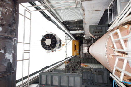Vlevo vidíme zvedaný aerodynamický kryt, vpravo pak tělo rakety Atlas V.