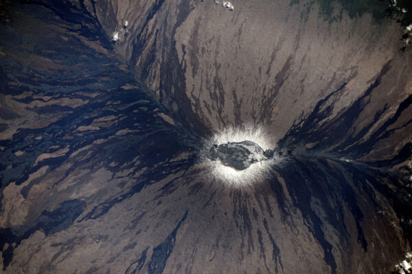 Už jste se někdy dívali přímo z nadhledu do aktivní sopky … z vesmíru? Takhle to vypadá. Sopka Mauna-Loa na Havaji má na svém vrcholku sníh a na jejích svazích se dají dobře rozeznat pruhy ztuhlé lávy.