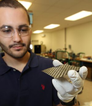 Daniel Perez, Ph.D. ukazuje uhlíkovou strukturální destičku nové baterie 