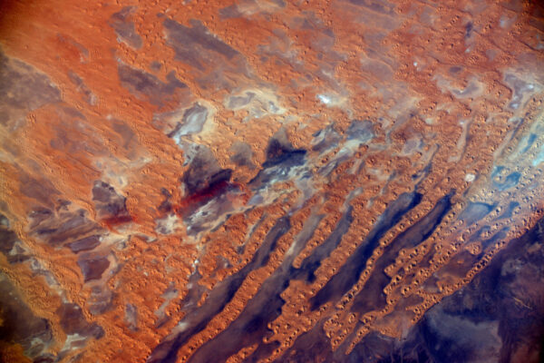 Oranžový písek částečně zakrývající každý barevný tón skal.