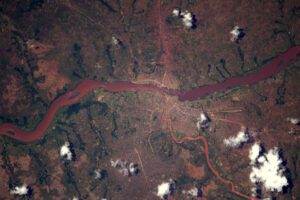 Řeka Kasai protéká v Kongu okolo města Tshikapa. Červenou barvu pravděpodobně způsobují sedimenty. Vypadá to, že mají napravo (na jihu) hezkou letištní ranvej. Líbí se mi, jak cesta nahoře vypadá, jako by vtékala do řeky na druhé straně břehu.