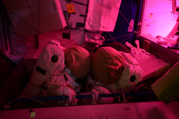 Intimní atmosféra vesmírné stanice: v noci se tyto dva skafandry společně proplétají… tajemné růžové světlo skleníku v Columbu na scéně jen přidává.