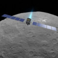 Tento obrázek tvoří počítačová vizualizace sondy Dawn, která je však zasazena do skutečného snímku trpasličí planety Ceres, který pořídila sonda Dawn.