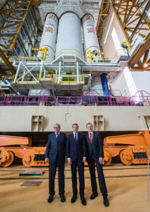 Ředitel ESA Jan Woerner (vpravo) s francouzským prezidentem Emmanuelem Macronem (uprostřed) a Evropským komisařem Jean-Calude junckerem (vlevo) během jejich společné návštěvy kosmodormu v Kourou 27. září. V pozadí stojí raketa Ariane 5 určená k prosincovému startu se čtyřmi družicemi Galileo.