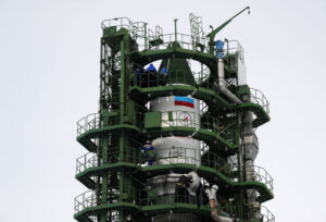 Dvě poloviny obslužné věže obklopují raketu a technici kontrolují všechny systémy.