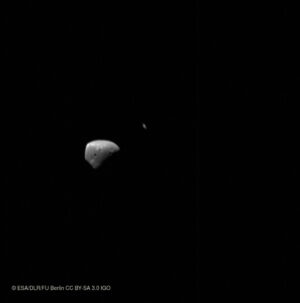 Deimos a za ním procházející Saturn
