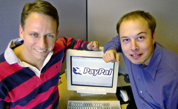 Výkonný ředitel firmy PayPal Peter Thiel a zakladatel Elon Musk pózují u loga své firmy v centrále v kalifornském Palo Altu.