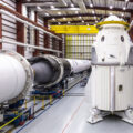 Crew Dragon pro nepilotovanou misi DM-1 v montážní hale vedle rakety Falcon 9 pro tuto misi.