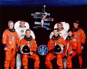 Oficiální foto posádky STS-86: (zleva) Chrétien, Parazynski, Bloomfield, Wetherbee, Titov, Lawrence, Foale. Wolf zatím chybí...