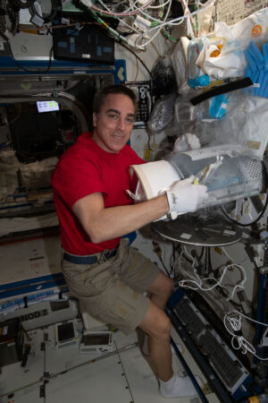 Chris Cassidy při práci s ledničkou MELFI (Minus Eighty-Degree Laboratory Freezer for ISS)