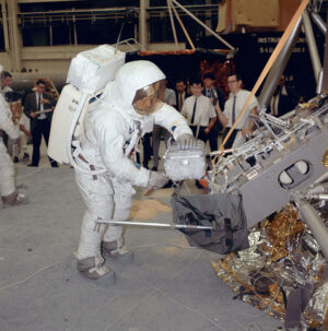 Neil Armstrong, velitel mise Apollo 11, nacvičuje v budově 9 na Manned Spacecraft Center v Houstonu manipulaci s pouzdrem na vzorky z Měsíce.