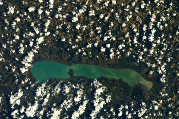 Tady vykukuje z oblaků Blatenské jezero. Že jej neznáte? Stačí říct Balaton v Maďarsku. Středoevropské moře (skoro nejde dohlédnout druhý konec, když tam stojíte). Bledě zelená barva signalizuje, že je poměrně dost mělké. I Thomas je rád, že si jej tentokrát nepopletl s jiným, přeci jen je snadno rozpoznatelné svým tvarem. Zdroj: flickr.com
