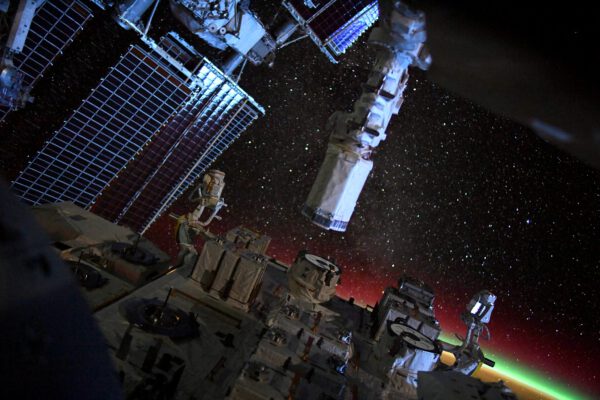 Technologie a příroda - moduly a solární panely ISS, hvězdný vesmír a polární záře nad Zemí. Zdroj: flickr.com