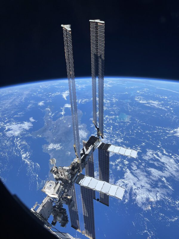 Sluneční panely stanice z neobvyklého nadhledu. Fotogorafii pořídil iPhonem z okénka Sojuzu MS-20 Yusaku Maezawa při příletu ke stanici 