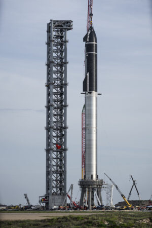 Loď Starship usazená na raketu Super Heavy - foceno na vzletové rampě pro orbitální mise na základně Starbase (Boca Chica) v jižním Texasu.