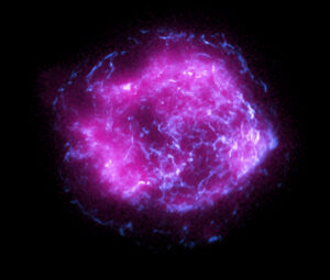 Cassiopeia A - pozůstatek supernovy. Fialovou oblast vyfotil rentgenový teleskop IXPE, modrá barva pochází od teleskopu Chandra a značí vyšší energie rentgenového záření.