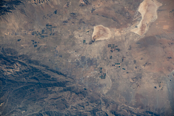 Vpravo nahoře vidíme vojenskou Edwardsovu základnu včetně ranveje pro přistání raketoplánů. Vlevo dole v okolí města Lancaster jsou pro pouštní oblasti typická kruhová pole s umělou závlahou. Zdroj: flickr.com