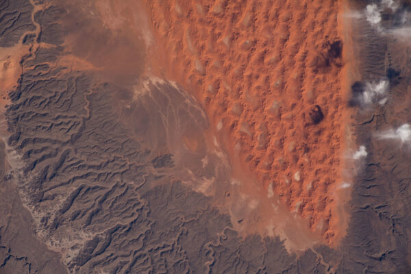 Podivuhodný snímek kombinace barev a tvarů zobrazuje část alžírské pouště Sahara. Vidíme písečné duny, skalnaté plošiny a plata pískovcových skal. Zdroj: flickr.com