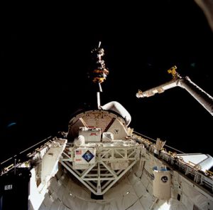 Nákladový prostor raketoplánu Columbia. Nahoře je vidět právě vypouštěná družice LAGEOS II, vzadu lze vytušit logo programu USMP-1, v jehož rámci se do kosmického prostoru podíval i Lambda Point Experiment.
