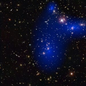 Na kupách jako je Abell 2744 lze testovat naše představy o temné hmotě. Zde vidíte snímek z Hubbleova dalekohledu s rozložením temné hmoty (modře).