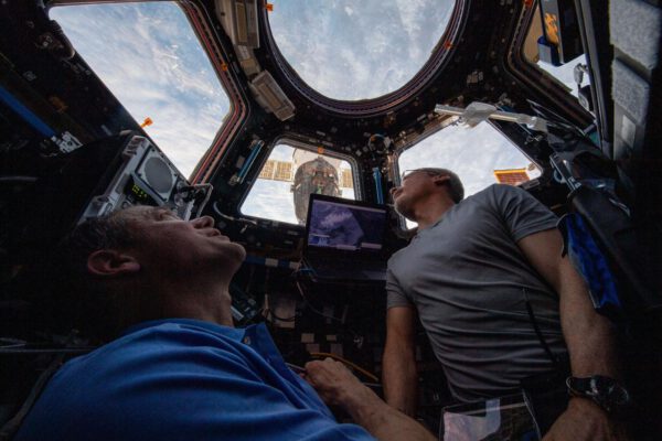 Thomas Marshburn a Mark Vande Hei se dívají z oken modulu Cupola stanice na Zemi