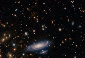 Výřez z předchozího snímku se zaměřením na relativně blízkou spirální galaxii LEDA 2046648. Všimněte si, že je u ní dobře patrný jasný galaktický střed a zřetelně viditelná jsou též jednotlivá spirální ramena. 
