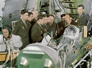 Šestice kosmonautů spolu s Nikolajem Kamaninem naslouchá výkladu Olega Ivanovského o katapultovacím křesle, na něž v kabině Vostoku za pár desítek minut jako první usedne Jurij Gagarin...