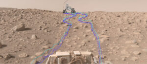 Tento složený snímek zachycuje cestu roveru Perseverance přes pole kamenů Snowdrift Peak. Základní fotografie vznikla 29. června. Rover na obzoru i čáry byly uměle doplněny až později ve vizualizačním nástroji JPL. Světle modrá čára ukazuje, kudy se pohybovaly středy předních kol roveru. Tmavší čáry pak patří šesti kolům roveru.