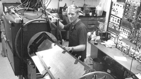 John Clauser stojí u experimentálního zařízení s nímž provedl svůj druhý test Bellových nerovností v roce 1976. 