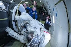 Zkoušky skafandrů firmy Collins Aerospace proběhly i na palubě letounu, který letem po parabolické dráze nakrátko navozoval stav snížené gravitace. Bývalý astronaut Danny Olivas (na snímku) zrovna testuje pohyb u makety přechodové komory modulu Quest.