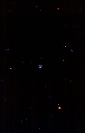 Vzdálený pohled na Einsteinův prstenec SPT-S J041839-4751.8.