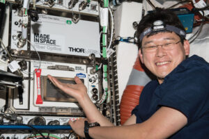 Japonský astronaut Norišige Kanaj pózuje u přístroje na výrobu optických vláken od Made in space.