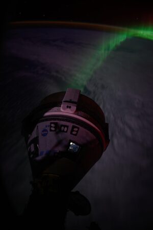 Starliner a polární záře vyfocené z okénka lodi Crew Dragon.