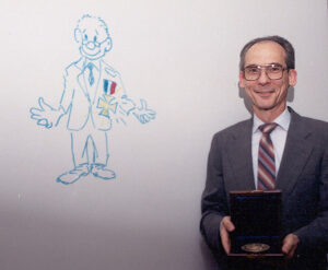 Ed Stone stojí vedle kresby, kterou nakreslil jeho kolega, když Ed získal Národní medaili za vědu v roce 1992.