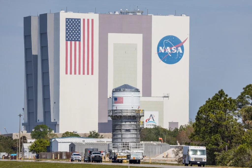 V pozadí vidíme halu VAB, kde se skládá raketa SLS.