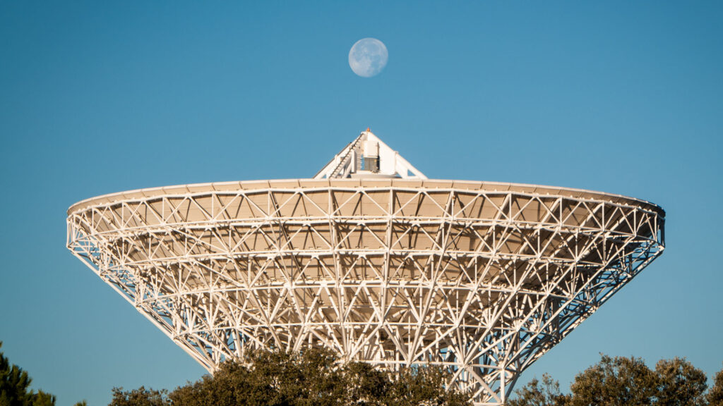 Měsíc vyfocený nad parabolou antény na španělské stanici Cebreros sítě Estrack.
