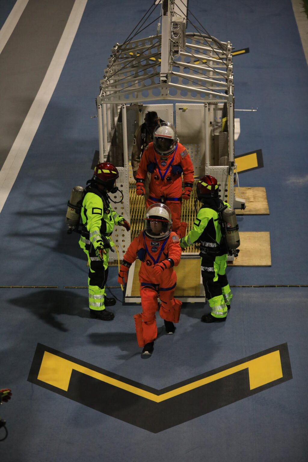 Christina Koch, specialistka mise Artemis II, a Victor Glover, pilot mise Artemis II, nacvičují výstup z únikového koše u rampy LC-39B na Kennedyho vesmírném středisku na Floridě 12. srpna 2025.