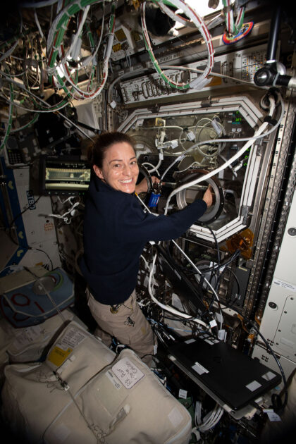 NASA astronautka Nicole Mann (Expedice 68) mění vzorky uvnitř rukavicového boxu Microgravity Science Glovebox pro fyzikální experiment, jenž zkoumá pasivní chlazení elektroniky v mikrogravitaci. Obrázek ukazuje, jak se v beztíži pracuje s uzavřenými experimenty – tekutiny se zde nesmí volně vznášet a hrozí kontaminace.