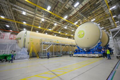 Vpravo kyslíková nádrž, vlevo vodíková nádrž centrálního stupně SLS pro Artemis III. Pohled na spodní kupole nádrží, 27. srpna 2025