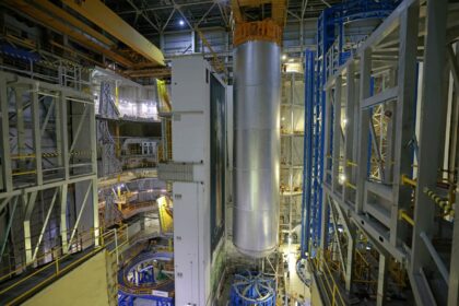 14. listopadu 2025 byla svařená vodíková nádrž vyzvednuta ze svařovacího nástroje VAC (z modré konstrukce vpravo) do výrobní buňky A (vlevo)