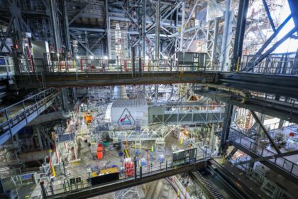 Uvnitř budovy VAB 4. prosince 2025: přístupové rameno CAA s bílou místností, za ní Orion