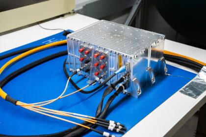 Prototyp zařízení pro řízení náboje pro LISA leží na laboratorním stole na Goddardově středisku v květnu 2025. Každá ze tří kosmických sondy mise LISA bude vybavena zařízením pro řízení náboje, které omezí hromadění elektrického náboje na zlatých a platinových referenčních hmotách, které budou volně létat uvnitř kosmické sondy. Zařízení vyvíjí University of Florida v Gainesville a Fibertek Inc. v McNairu ve Virginii.