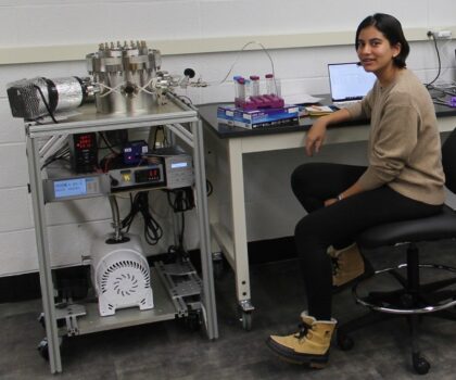 Výzkumnice Mariam Naseem u přístroje Simulator of Ocean World Cryovolcanism na University of Maryland, který vstřikuje kapalné roztoky do vakuové komory.