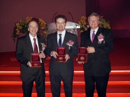 Čerství laureáti se fotografují se svými Nobelovými cenami. Vlevo Saul Perlmutter, uprostřed Adam Riess, vpravo Brian Schmidt.